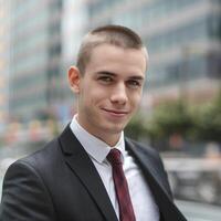 A man in a suit and tie standing in front of a building photo