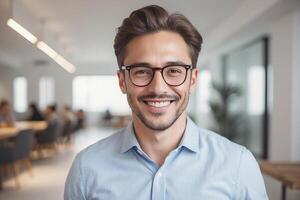 A man with glasses and a blue shirt is smiling photo