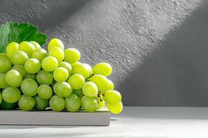 Fresh green grapes arranged on light surface with leaf, showcasing their vibrant color and texture. Perfect for healthy eating and culinary presentations photo