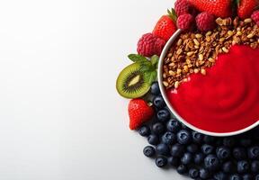 Colorful smoothie bowl with strawberries, blueberries, raspberries, and granola, garnished with kiwi and mint leaves, creating vibrant and healthy breakfast option photo