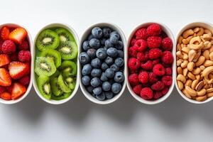 Fresh fruits and nuts in bowls, including strawberries, kiwi, blueberries, raspberries, and cashews, create vibrant and healthy display photo