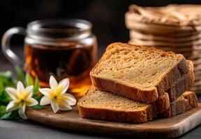 Freshly sliced homemade bread with tea and flowers on wooden board, creating warm and inviting atmosphere. Perfect for breakfast or cozy afternoon snack photo