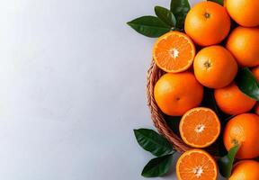Fresh tangerines in wicker basket with green leaves on light background, showcasing vibrant colors and healthy, appetizing look photo