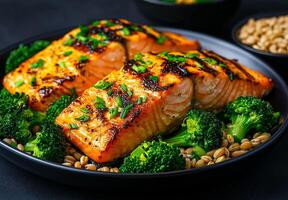 Grilled salmon fillets served with broccoli and barley wheat, garnished with fresh herbs, create vibrant and healthy meal. dish is visually appealing and nutritious photo