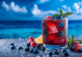 Colorful cocktail with blueberries, raspberries, and mint, served over ice, perfect for summer refreshment by beach. Enjoy vibrant colors and refreshing taste photo