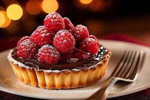 simple round chocolate tart topped with fresh raspberries, dusted with powdered sugar, served on plate with fork. warm bokeh background adds cozy atmosphere photo