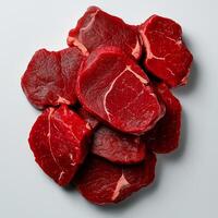 Fresh raw beef steaks stacked on white background, showcasing rich red color and marbling. Perfect for culinary presentations and meat dishes photo