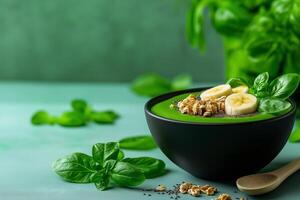 vibrant smoothie bowl topped with banana slices, granola, and fresh basil leaves, set against soft green background, evokes sense of freshness and health photo