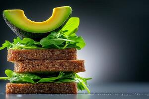 stack of whole grain bread slices topped with fresh avocado and arugula, showcasing healthy and vibrant meal. contrast of colors and textures creates appealing visual photo