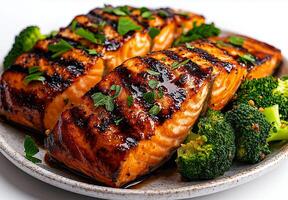 Grilled salmon fillet served with steamed broccoli, garnished with herbs, showcasing delicious and healthy meal. Perfect for food lovers and health enthusiasts photo