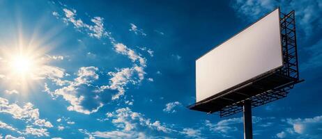 blank billboard stands against bright blue sky with fluffy clouds, illuminated by sun rays, creating vibrant and inviting atmosphere photo
