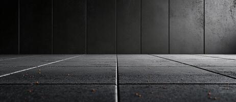 Empty concrete wall and asphalt floor create minimalist backdrop, showcasing modern industrial aesthetic. subtle texture and scattered debris add depth to scene photo