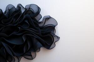 flowing black fabric with soft, ruffled textures creates elegant and dynamic visual. delicate layers evoke sense of movement and sophistication photo