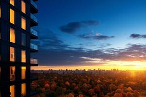high rise residential building with illuminated windows overlooks vibrant autumn landscape at sunset. city skyline is visible in distance, creating serene atmosphere photo