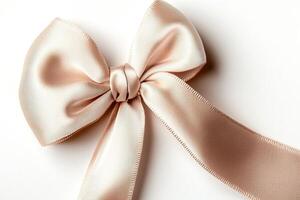 Delicate silk ribbon forms an elegant bow, showcasing soft fabric folds that catch warm lighting. The composition highlights the beauty of the ribbon against a clean, white backdrop photo