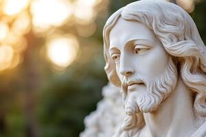 A detailed sculpture of Jesus stands serenely. Gentle sunlight filters through trees, casting a warm glow. The soft-focus background enhances the spiritual and cinematic feel photo