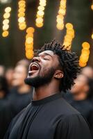A choir sings with obvious joy in a natural setting. Soft golden morning light illuminates the singers. Background trees are blurred, adding to the serene and spiritual feeling photo