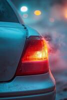 A faintly flickering rear brake light on a ruined vehicle illuminates the night, surrounded by rising smoke, creating a haunting atmosphere of stillness and destruction photo