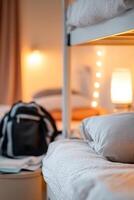 Soft-focus warm lighting creates a cozy atmosphere in a shared hostel dormitory filled with multiple bunk beds, travel gear, and backpacks scattered around, perfect for budget travelers photo