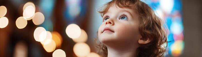 A young child stands inside a church, looking up in wonder as colorful light from stained glass projects brilliantly across their face, creating a spiritual atmosphere photo