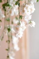 Delicate floral streamers adorned with small white flowers and lush green vines float gently overhead, creating a soft-focus backdrop ideal for text placement, perfect for events photo
