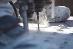 Multiple drill bits operating on a work surface in a workshop photo