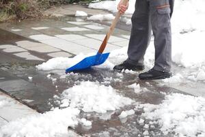 Shoveling snow from a walkway during winter cleanup photo