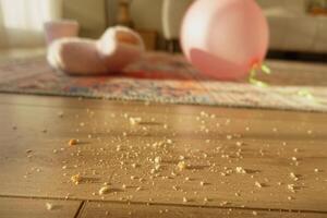 Messy living room with crumbs and a pink balloon on the floor photo