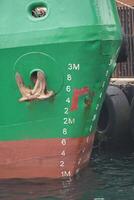 Cargo ship moored at dock with visible depth markings in morning light photo