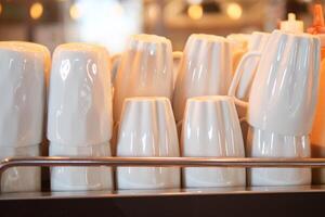 Stacked white mugs on a countertop in a cozy cafe setting photo
