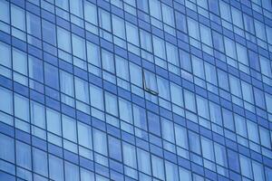 Modern building facade with reflections of sky and missing window photo