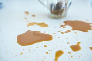 Coffee spills across a white table surface during afternoon gathering photo