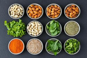 Balance plant based choice concept. A vibrant display of various nuts, seeds, and greens arranged in small bowls, emphasizing healthy eating and nutritious ingredients. photo