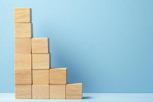 Growth mindset habits concept. Wooden blocks arranged in a growing staircase pattern against a blue background. photo