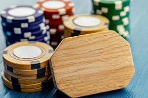 A close-up of poker chips in various colors stacked on a blue surface, showcasing a wooden chip prominently in the foreground. photo