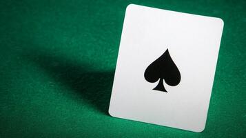 A close-up of a playing card featuring the spade symbol, set against a green background, evoking themes of gaming and chance. photo
