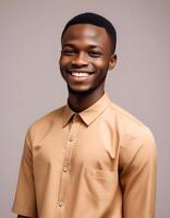 Brightly smiling Nigerian male in a fashionable ensemble, offering a confident expression, against a simple background photo