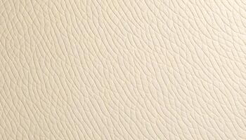 Soft beige leather grain texture background with a uniform appearance, highlighting the fine grain under bright light, giving it a smooth and polished look photo