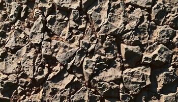 Rough, rocky surface with irregular, jagged shapes and textures, appearing to be a natural stone or rock formation photo