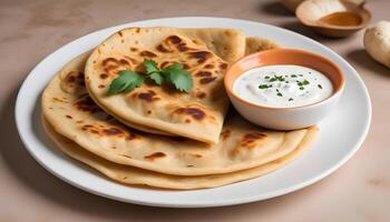 Warm, freshly made aloo paratha served with a side of yogurt photo