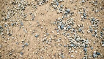 Textured gravel background with a sandy overlay, featuring fine grains mixed with coarse gravel, providing a unique contrast in texture photo