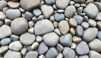 Smooth gray and white river rocks of various sizes arranged in a natural pattern photo