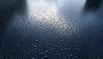 Tarmac texture background covered in a light layer of rain, reflecting a cloudy sky and showing water droplets on the surface photo