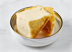 Crispy Fried Tofu served in bowl isolated on marble background side view of singapore food photo