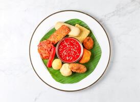 Malaysian Rojak set with Peanut Sauce, fried fritters, vegetables, and tofu served in plate isolated on marble background top view of singapore food photo