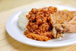 Grilled Pork chop with White Rice, Mince meat sauce served in plate isolated on table closeup side view of Hong Kong food photo