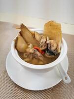 Fish head soup with Gastrodia elata, Chuanxiong and Angelica dahurica served in broth isolated on background side view of Hong Kong food photo
