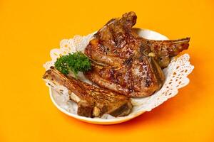 Grilled Lamb Rack or Lamb Chops served in plate isolated on orange background side view of hong kong food photo