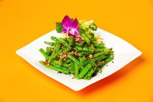 Stir Fried Green Beans with Minced Pork and Olives served in plate isolated on orange background side view of hong kong food photo