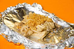 Baked Mushrooms with Butter and garlic served in plate isolated on orange background side view of hong kong food photo
